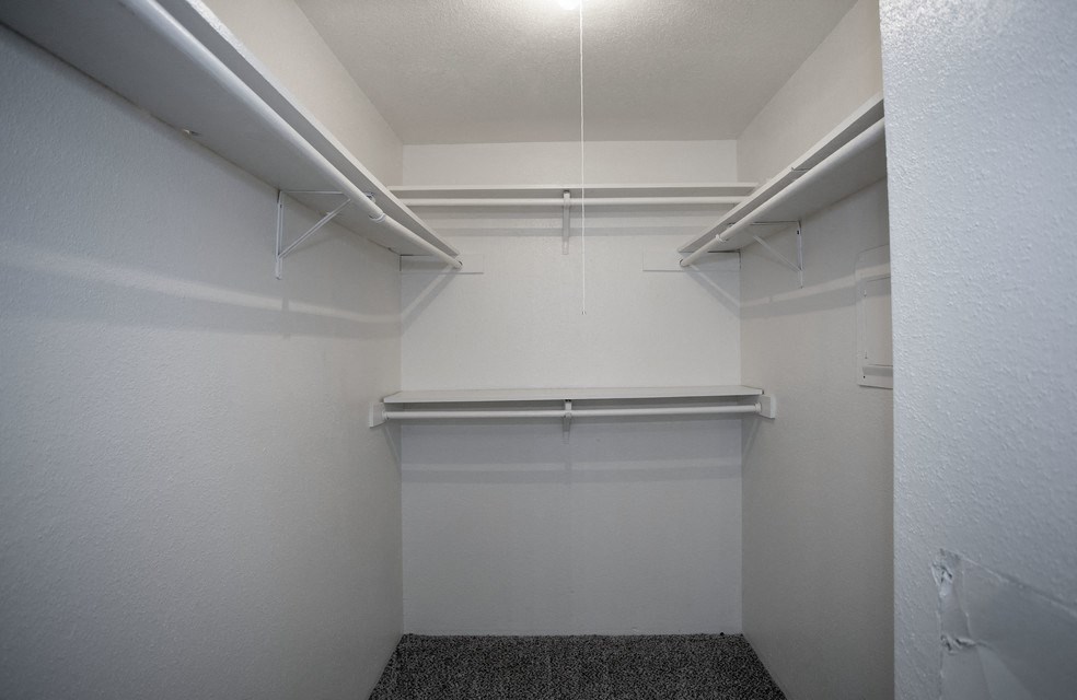 a walk in closet in an empty room with white walls