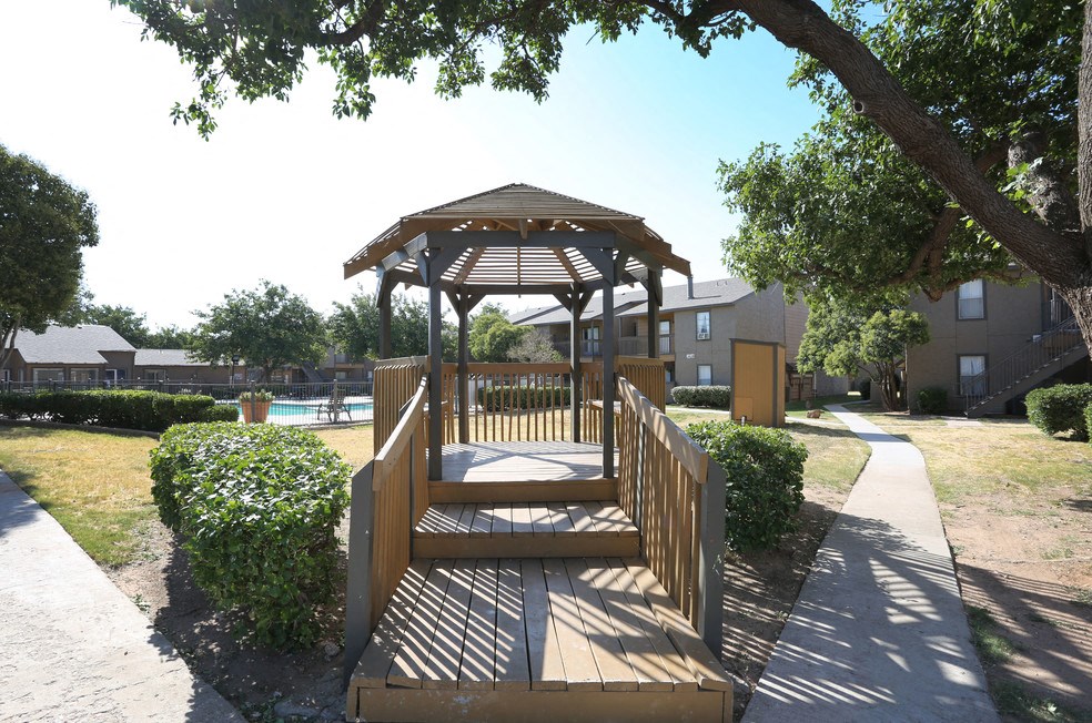 a wooden deck with a gazebo in front of a pool