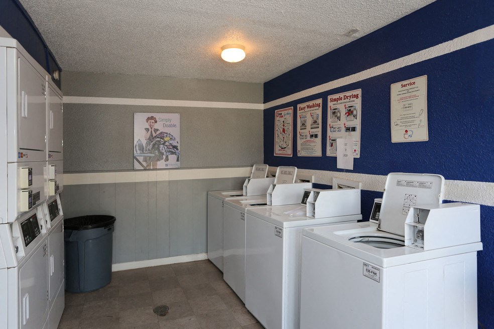 a laundry room with washes and dryers in it and posters on the wall
