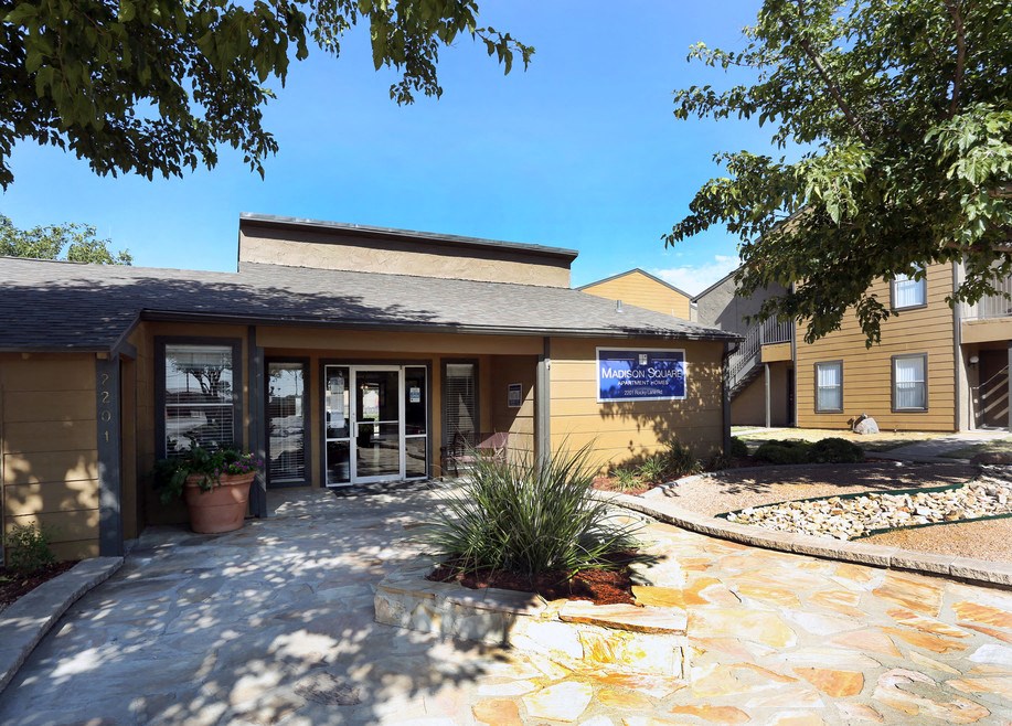 the front entrance of a yellow building with a blue sign