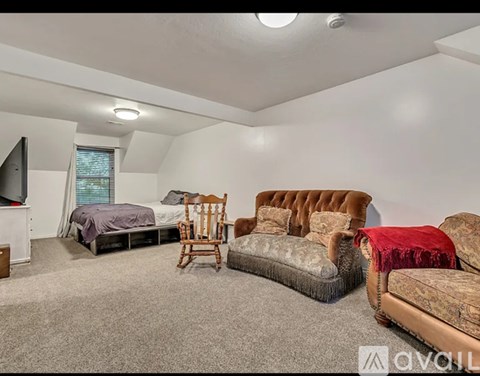 A bedroom with a bed, a chair, and a couch.