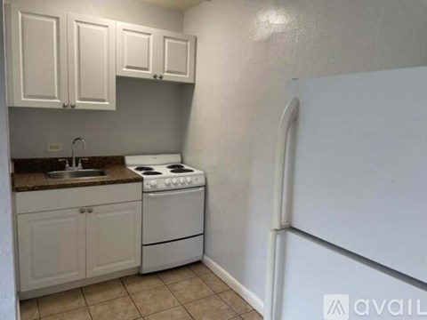 A kitchen with white appliances and cabinets.