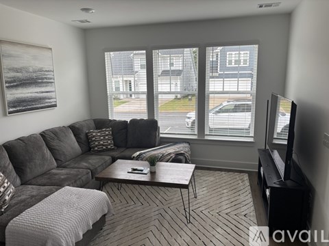 A living room with a grey sofa and a coffee table in front of a window.