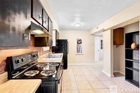 A kitchen with black appliances and wooden cabinets.