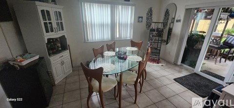 A kitchen with a table and chairs in the middle of the room.