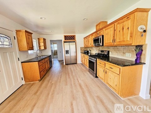 A kitchen with wooden cabinets and a black countertop.