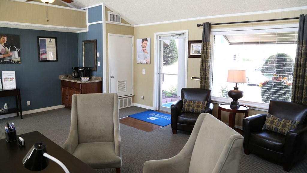 a living room with chairs and a table and a window