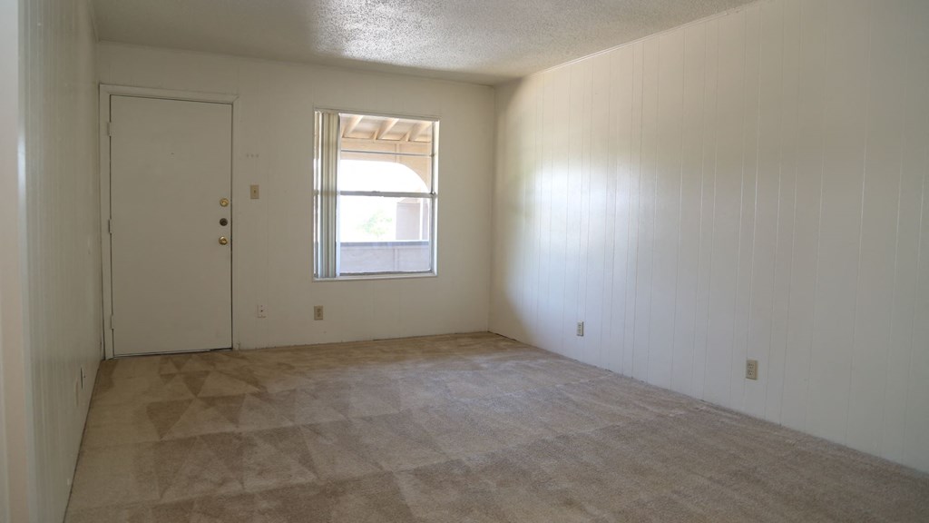 the living room of an empty house with a window