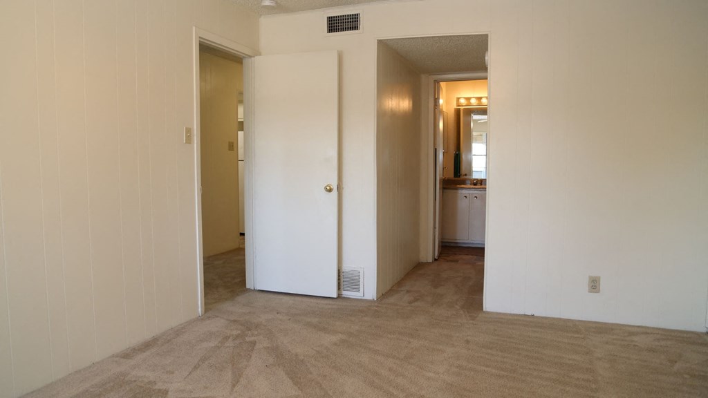 the living room is empty and the hallway is open to the bedroom and the bathroom