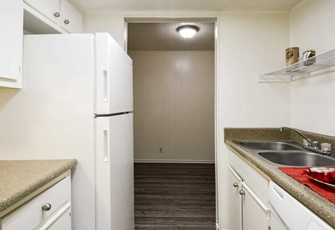 a kitchen with white cabinets and a sink and a refrigerator