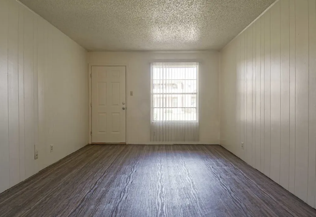 the living room of an empty house with a wooden floor