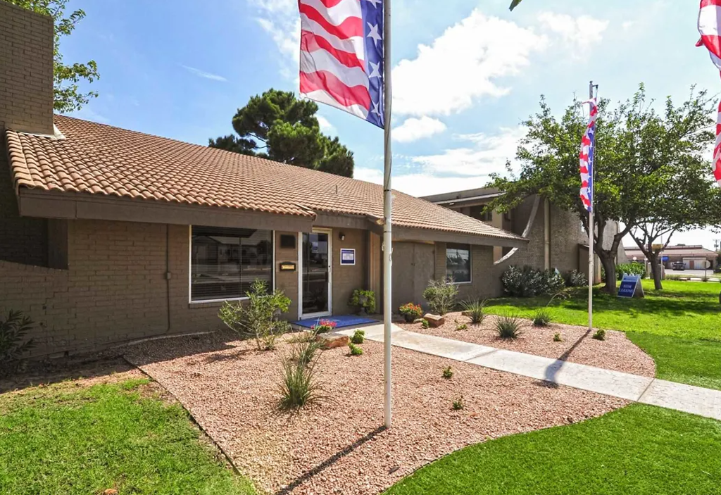 the front of a building with two flags in front of it