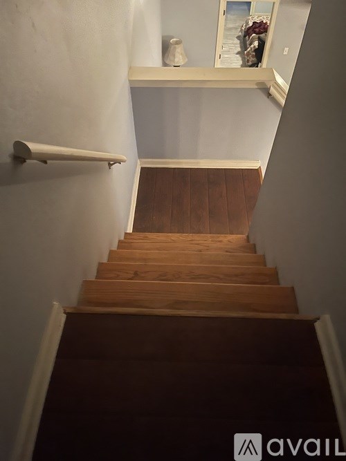 A staircase with wooden steps and a white handrail.