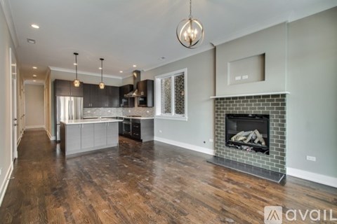 A modern kitchen with a fireplace and wooden floors.