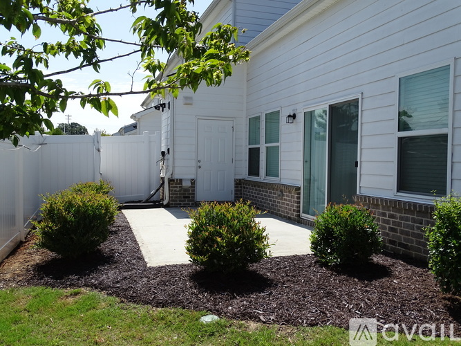 A white house with a white fence and a white walkway leading to the front door.