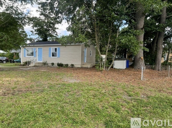 A room with a ceiling fan and wooden flooring.