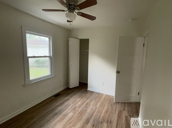 A room with a ceiling fan and a window.