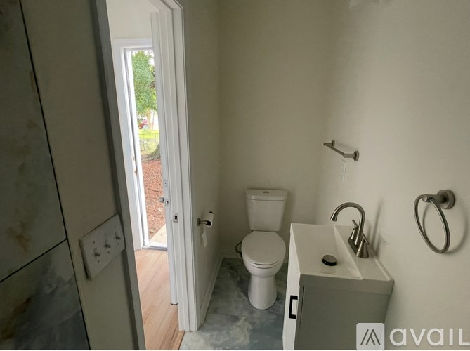 A bathroom with a toilet, sink and shower.