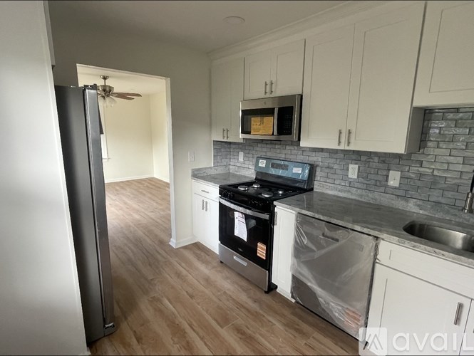 A kitchen with a refrigerator, stove, and microwave.