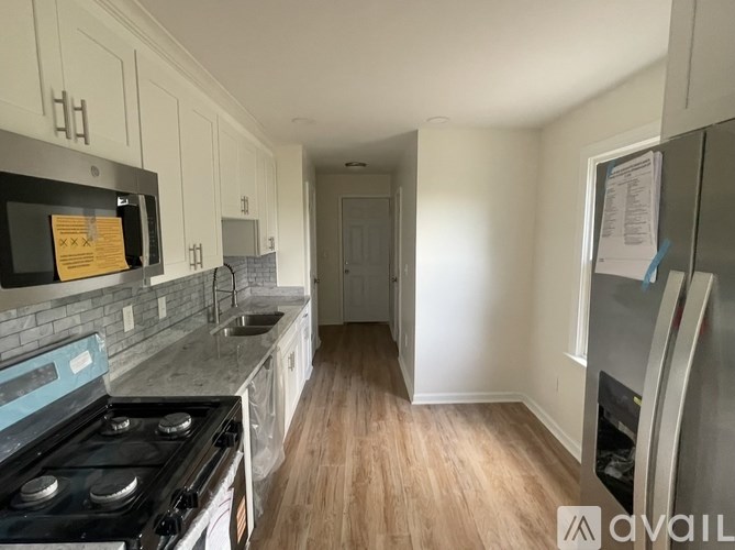 A kitchen with a black stove top oven and a white fridge.