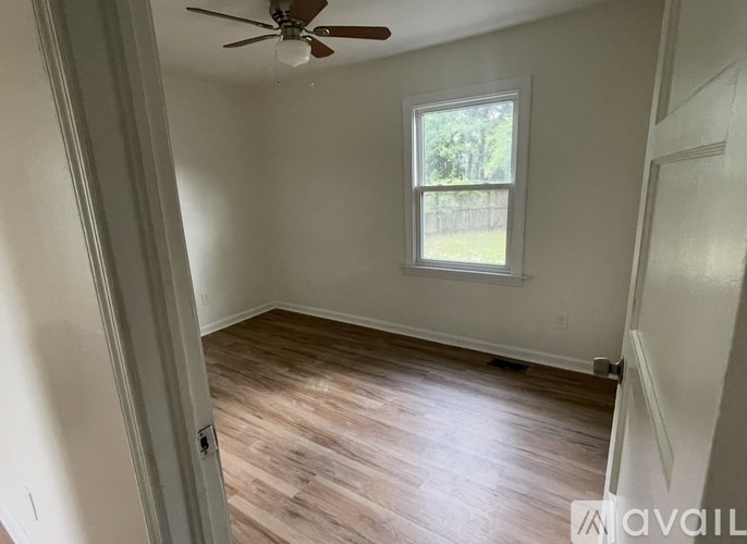 A room with a ceiling fan and a window.