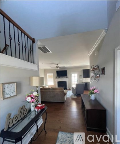 A living room with a couch, a television, and a coffee table with flowers on it.
