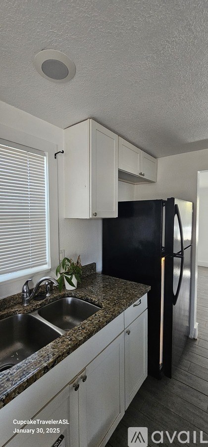 A kitchen with black appliances and white cabinets.