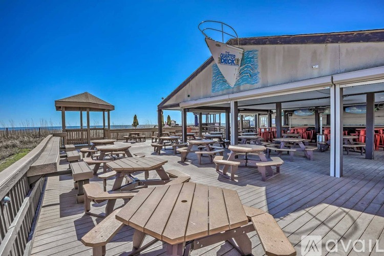 A wooden deck with picnic tables and a gazebo is shown.