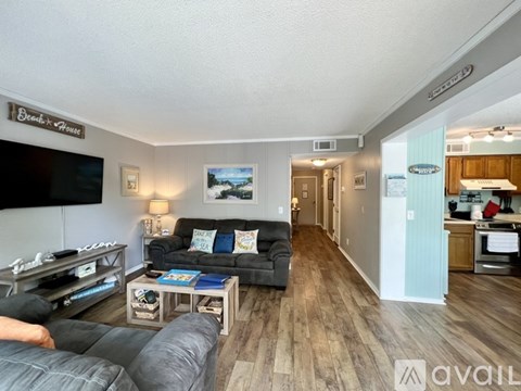 A living room with a grey couch and a wooden floor.