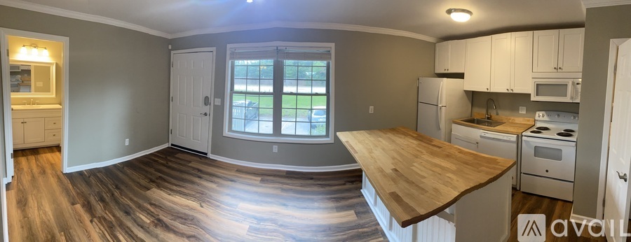 A kitchen with a wooden countertop and white appliances.