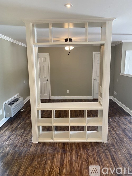 A room with a wooden floor and a white cabinet.