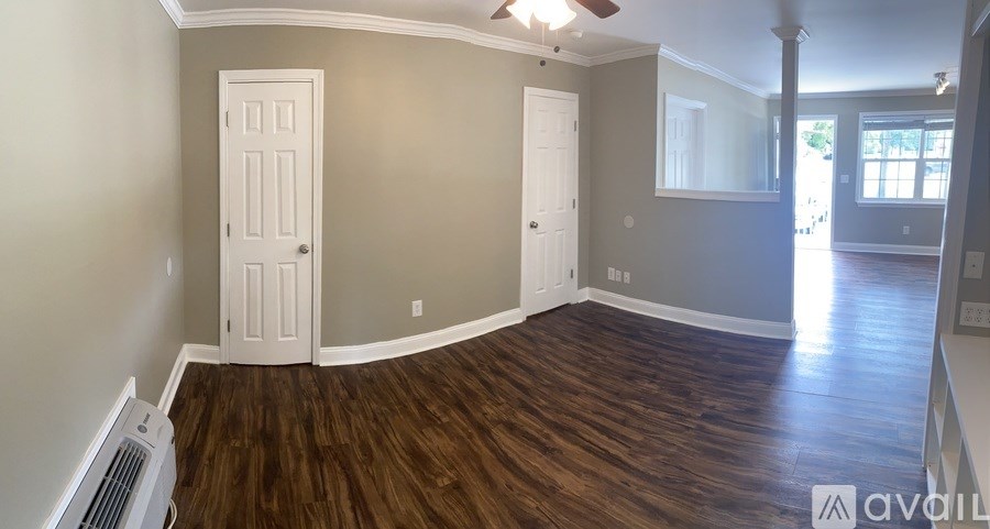 A room with wood flooring and a white door.