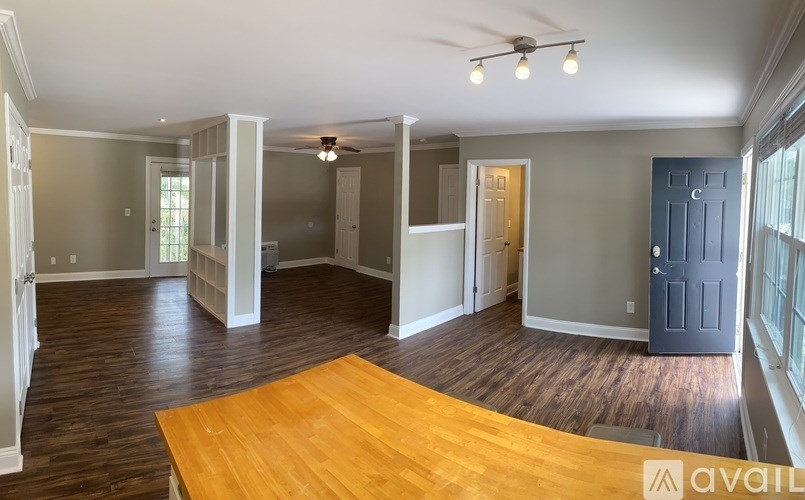 A spacious room with a wooden floor and a ceiling fan.