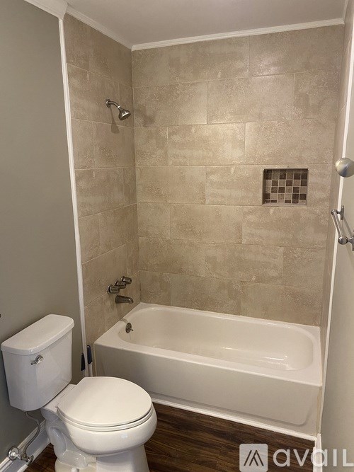 A white toilet sits next to a bathtub in a bathroom.
