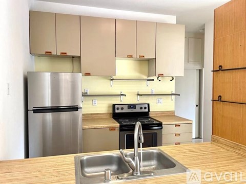 A kitchen with a stainless steel refrigerator and a stove with an oven.