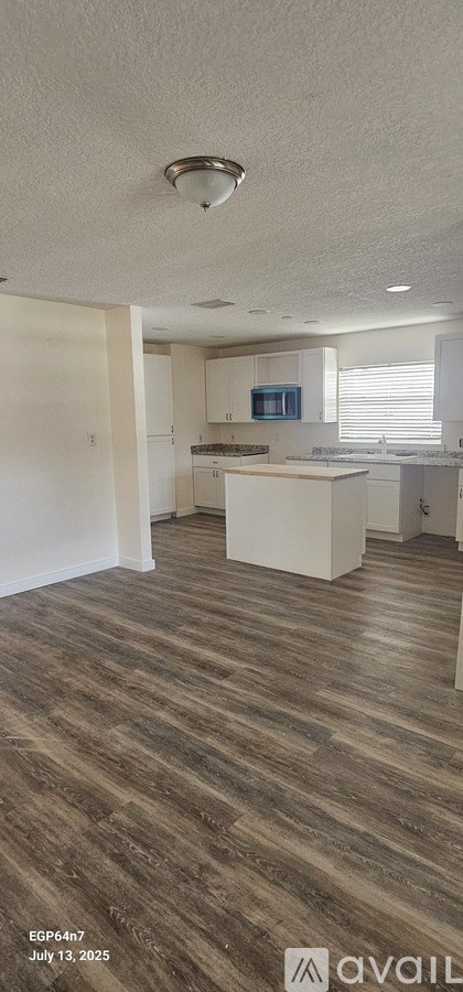 A kitchen with white cabinets and a microwave.