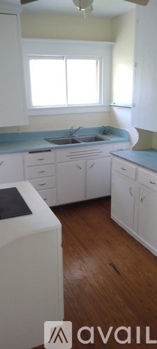 A kitchen with white cabinets and a blue countertop.