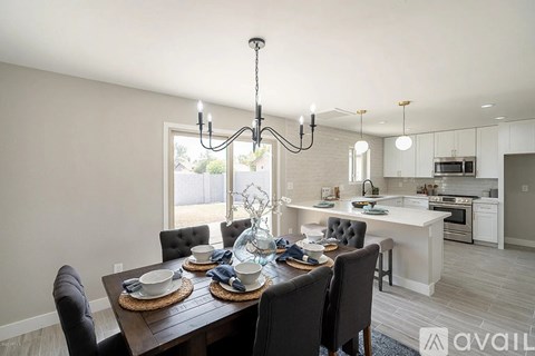 A dining room with a table set for six with a chandelier hanging above.