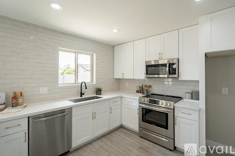 A kitchen with white cabinets and a stainless steel dishwasher.