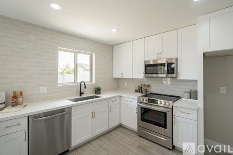 A kitchen with white cabinets and a stainless steel dishwasher.
