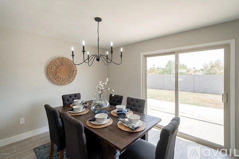 A dining room with a wooden table set for six.