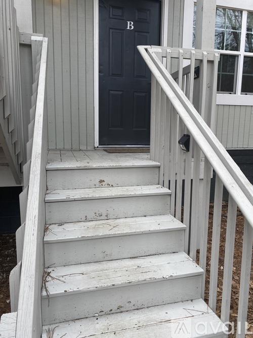 A set of stairs leading to a black door.