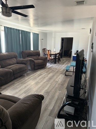A living room with a brown couch and a television.