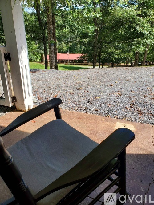 A black chair with a grey cushion is in front of a white door.