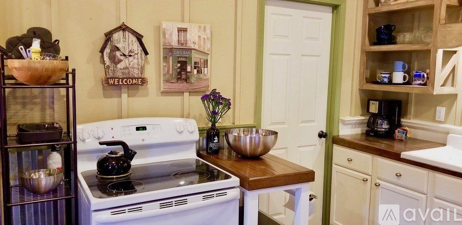 A kitchen with a white stove top oven and a white fridge.