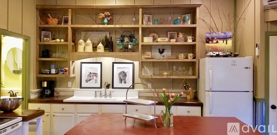 A kitchen with a white refrigerator, a sink, and a wooden table.