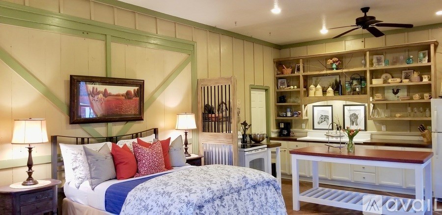 A bedroom with a bed, nightstand, and a painting on the wall.