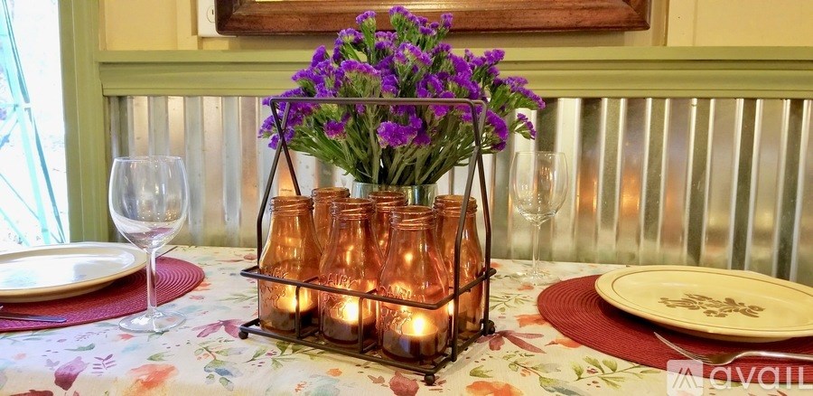 A table with a floral centerpiece and candles.