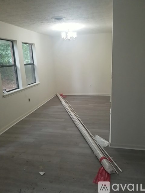 A room with a white wall and a window is available for rent.