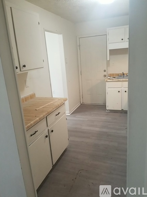 A kitchen with white cabinets and a wooden countertop.